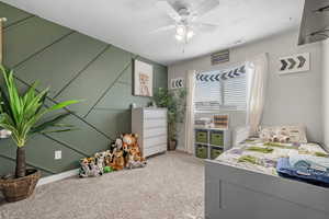 Bedroom featuring carpet floors, ceiling fan, and a textured ceiling