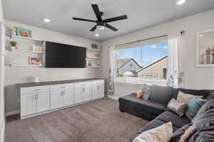Living area featuring light colored carpet, a ceiling fan, and recessed lighting