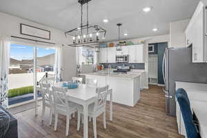 Dining room featuring wood finished floors, recessed lighting, a chandelier, and a textured ceiling
