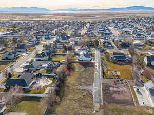 Aerial perspective of suburban area with property parcel outlined and mountains