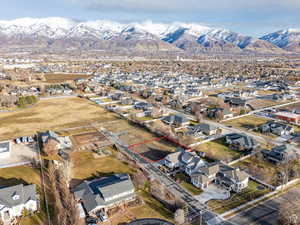 Aerial view of property and surrounding area with a mountainous background and nearby suburban area