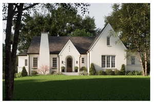 Tudor house featuring brick siding, a front lawn, and a chimney