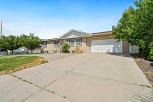 View of front of home with brick siding, concrete driveway, and a garage