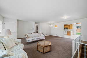 Carpeted living area with plenty of natural light and a chandelier