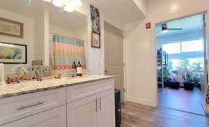 Bathroom featuring wood finished floors, vanity, and ceiling fan