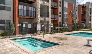 View of swimming pool with a community hot tub