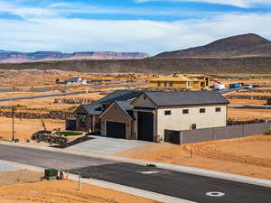 View of front of home with stone siding, a mountain view, an attached garage, driveway, and board and batten siding