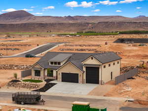 View of front of home featuring stone siding, an attached garage, concrete driveway, a mountain view, and a standing seam roof