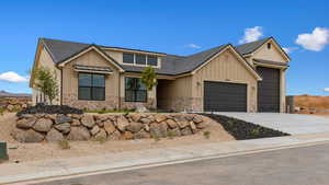 View of front of property featuring board and batten siding, a garage, and driveway
