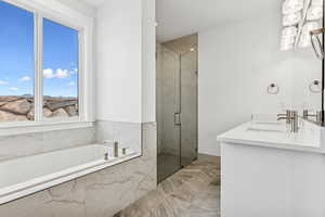 Full bath featuring a bath, a marble finish shower, and double vanity