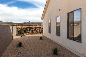View of side of home with a mountain view and stucco siding