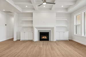 Unfurnished living room featuring coffered ceiling, beamed ceiling, recessed lighting, light wood-style floors, and a tile fireplace