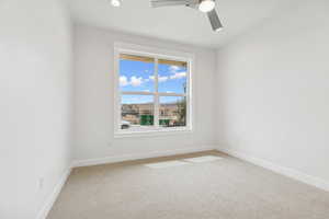 Carpeted empty room featuring a ceiling fan and recessed lighting