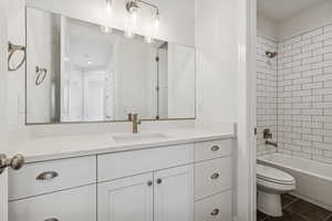 Bathroom with vanity, tile patterned floors, and shower / washtub combination