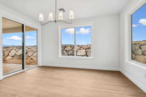 Unfurnished dining area featuring light wood-style flooring and baseboards