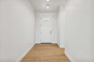 Doorway to outside featuring light wood-style floors and recessed lighting