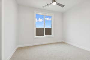 Spare room with light carpet and ceiling fan