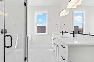 Full bathroom featuring double vanity, marble look tile flooring, and a marble finish shower