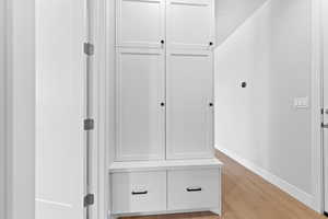 Mudroom featuring light wood finished floors and baseboards