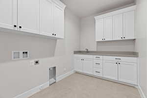 Laundry area with gas dryer hookup, hookup for an electric dryer, cabinet space, and hookup for a washing machine