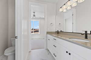 Bathroom featuring marble finish flooring, double vanity, and ceiling fan