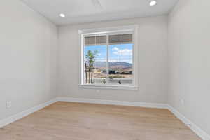 Spare room with a mountain view, light wood-style flooring, and recessed lighting