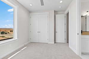 Unfurnished bedroom with light carpet, recessed lighting, a closet, and ceiling fan