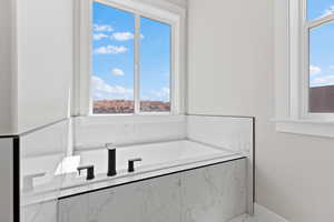 Bathroom with a bath and plenty of natural light