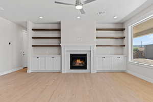 Unfurnished living room with a glass covered fireplace, light wood-style floors, ceiling fan, and recessed lighting