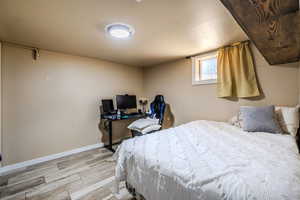 Bedroom with wood tiled floors and baseboards