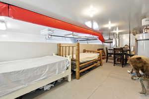 Bedroom with concrete flooring and secured water heater