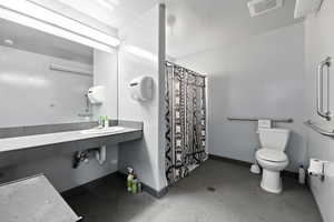 Bathroom with curtained shower and tile patterned floors
