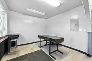 Home office with electric panel and concrete floors