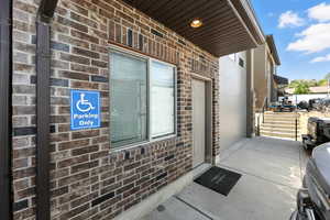 Doorway to property featuring brick siding
