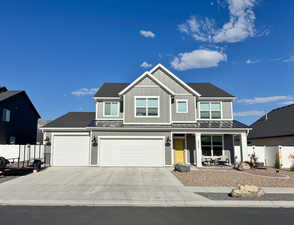 View of front of property featuring a porch, a standing seam roof, driveway, and a metal roof