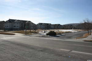 View of asphalt road with curbs, sidewalks, and a residential view