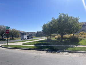 View of asphalt road with traffic signs, curbs, a residential view, and sidewalks