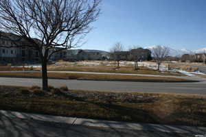 View of asphalt road featuring a mountain view and sidewalks