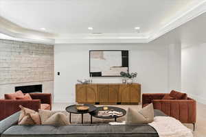 Living area with a raised ceiling, recessed lighting, and light wood-style flooring