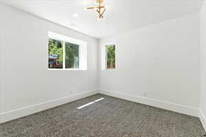 Spare room with baseboards and dark colored carpet