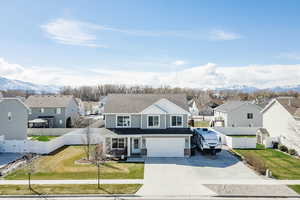 View of front of property featuring a residential view, driveway, a mountain view, a fenced backyard, and roof with shingles