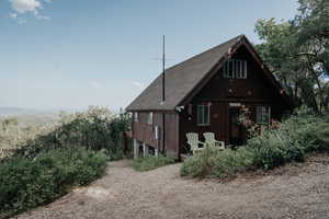 Back of house featuring a shingled roof