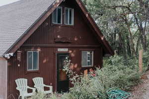 Back of house featuring a shingled roof