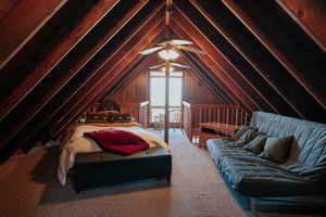 Carpeted bedroom with vaulted ceiling and a ceiling fan