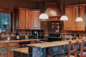 Kitchen with decorative backsplash, electric stove, dishwasher, pendant lighting, and custom range hood