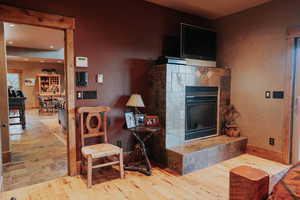 Living room featuring a tile fireplace, recessed lighting, and wood finished floors