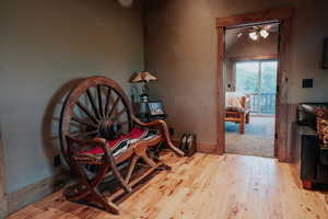 Sitting room with hardwood / wood-style floors, lofted ceiling, and a ceiling fan