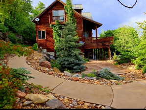 Back of house with a metal roof, a balcony, and a standing seam roof