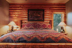 Bedroom featuring log walls