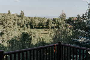 Balcony featuring a forest view